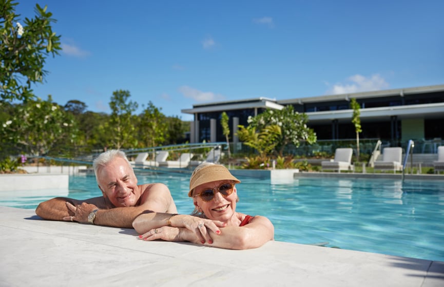 Couple relaxing on the side of the pool 