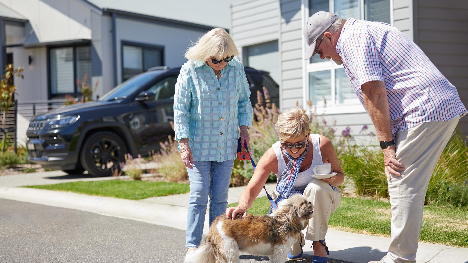 Friends meet in the streets with their dog in a Stockland Halcyon community