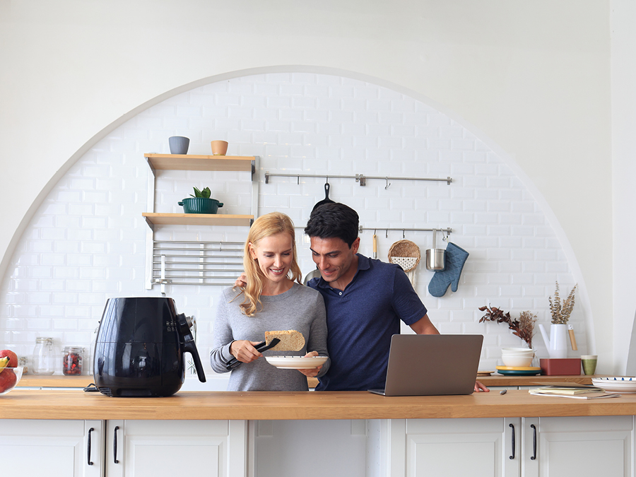 Woman and man cooking air fryer recipes in a kitchen