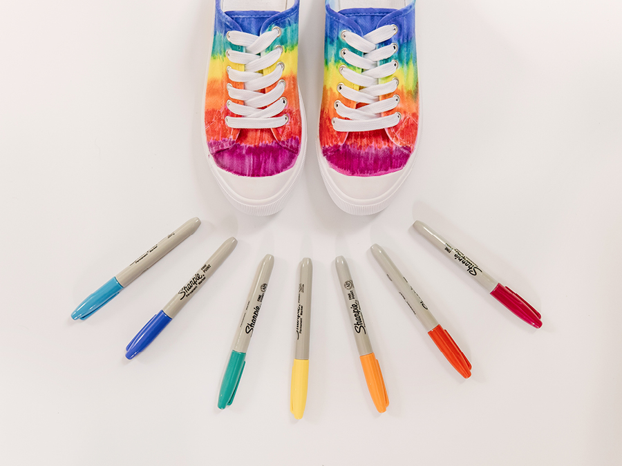 Multi-coloured sneakers with coloured permanent marker pens on display