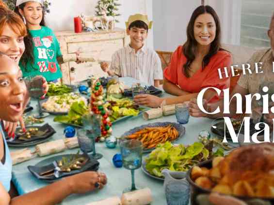 People sitting around a dining table filled with fresh food