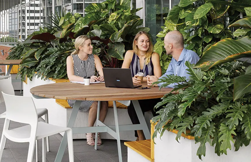 Colleagues at a table at the Stockland Brisbane office