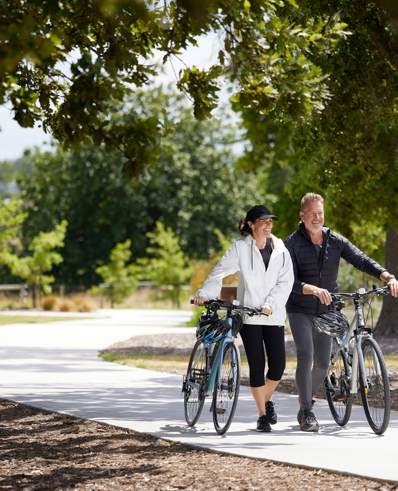 Couple walking on footpath with their bikes