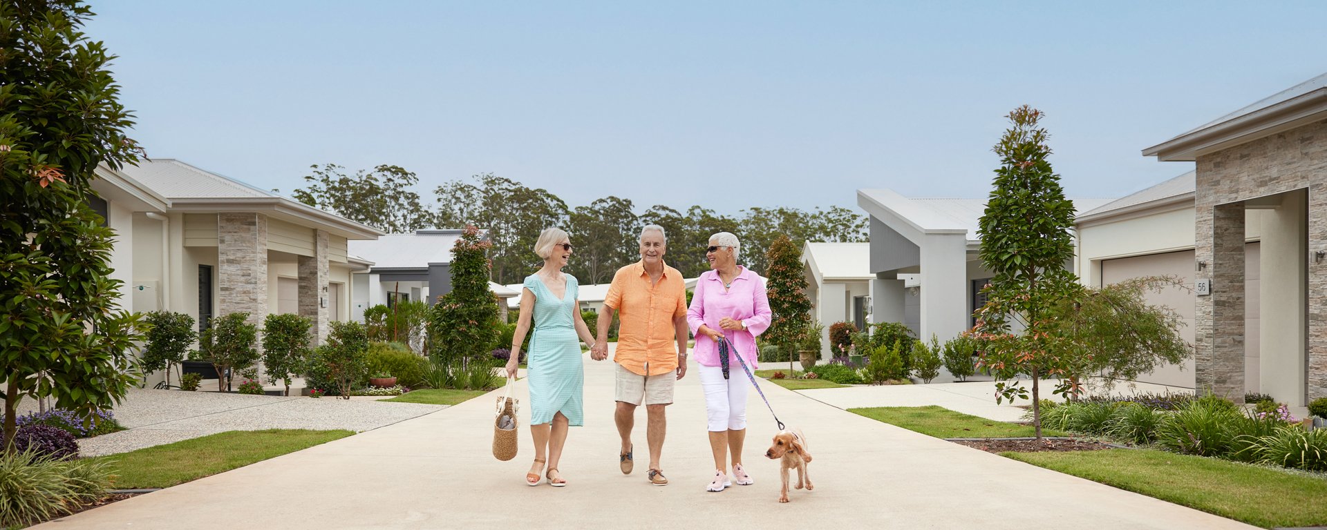 Friends walking in the streets of a Stockland Halcyon community with their dog