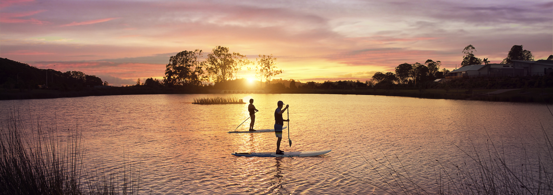 Homeowners enjoy an early morning sunrise and stand up paddle in the Stockland Halcyon Lakeside lake