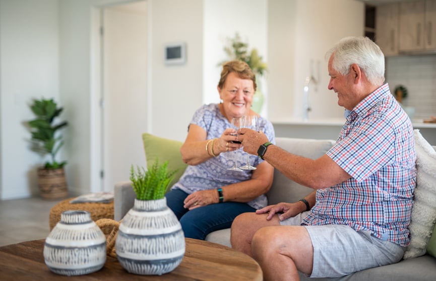 Couple enjoys a drink in the living room of their new Stockland Halcyon home