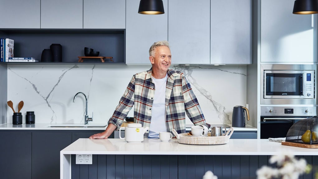 Man makes afternoon tea in the kitchen of his new Stockland Halcyon home