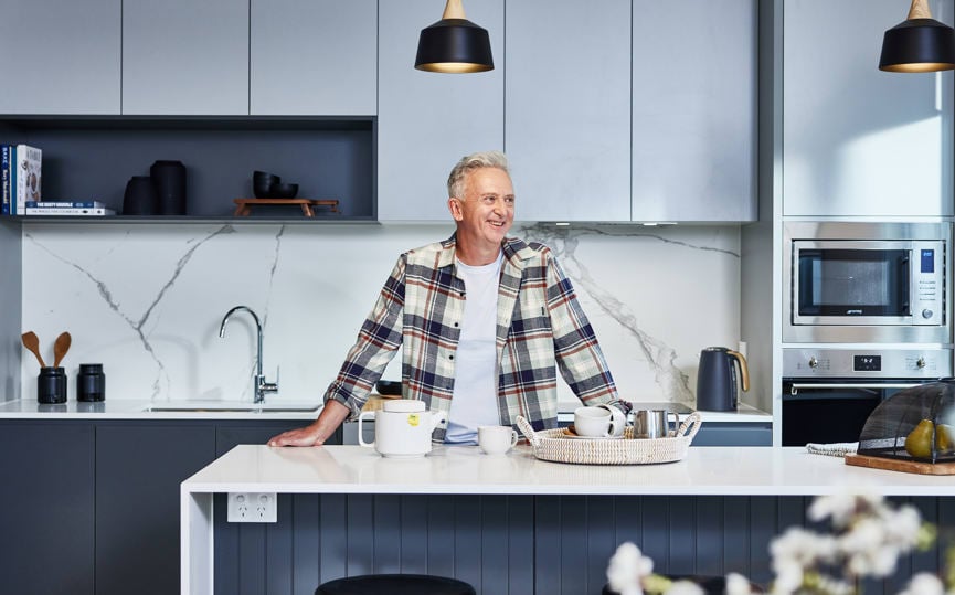 Man makes afternoon tea in the kitchen of his new Stockland Halcyon home