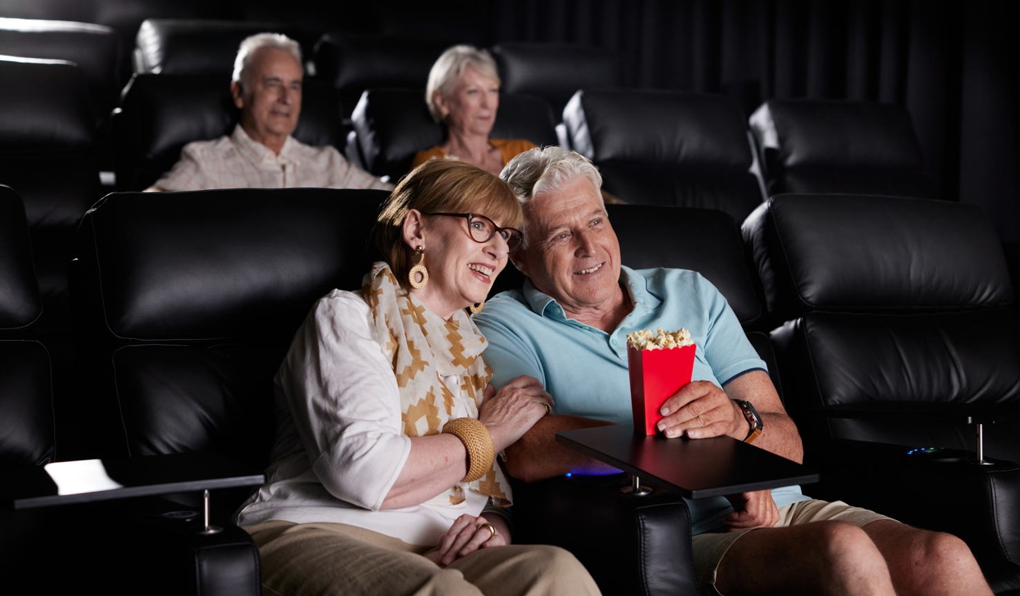 Friends watching a movie in the Gold-class style cinema at a Halcyon community