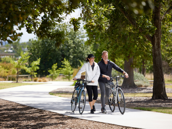 A couple riding bikes through a pathway and enjoying nature