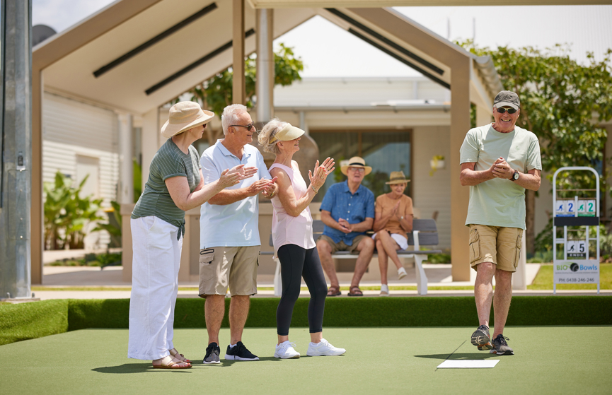 Group of friends playing lawn bowls in a Halcyon community