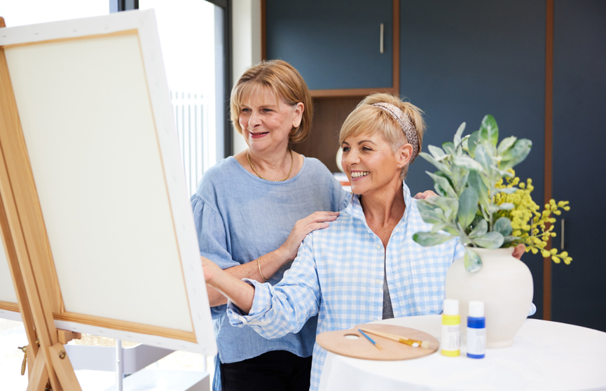 Two friends painting together at a Halcyon community