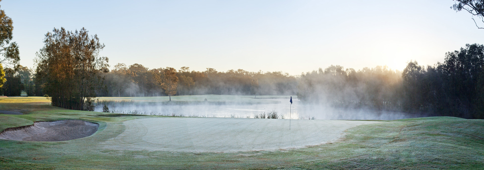 Landscape shot of Gainsborough Greens golf course and flag stick with steamy lake in background