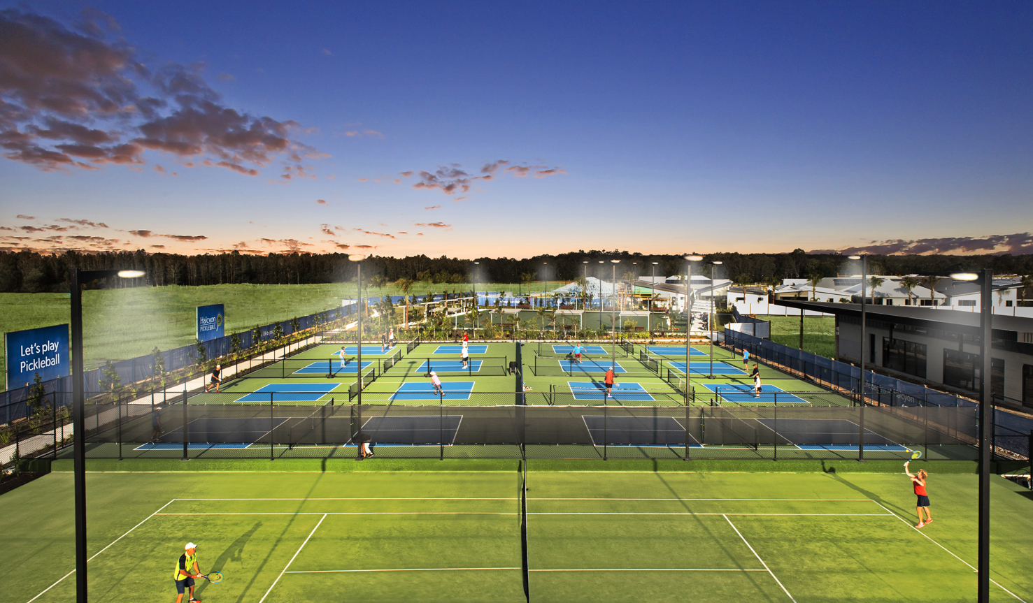 Evening drone shot of people playing on the floodlit tennis court and eight pickleball courts