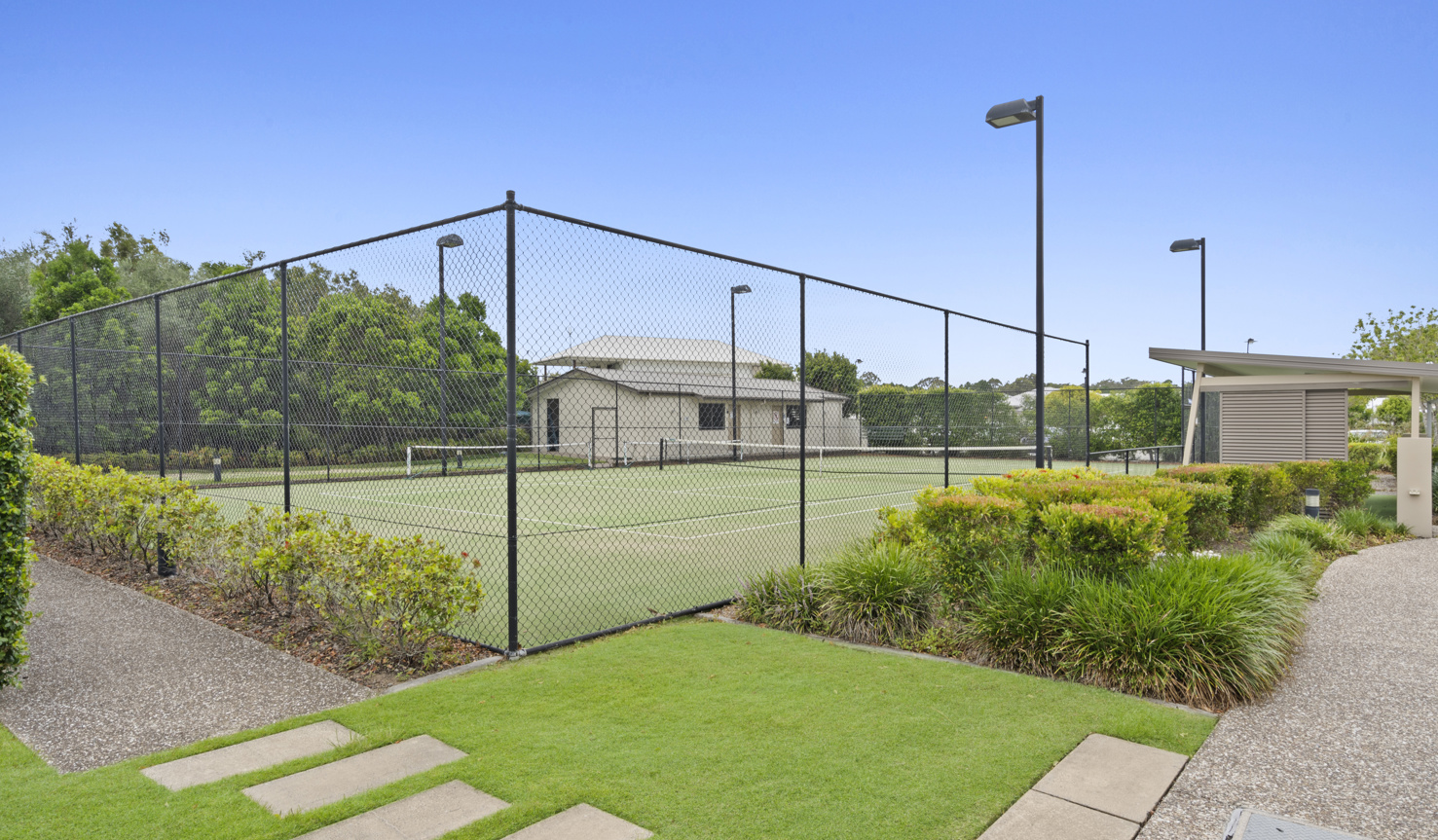 External shot of the Halcyon Waters floodlit tennis court