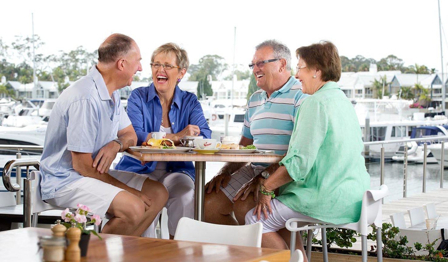 Group of homeowners laughing and chatting enjoying lunch at the Hope Island Boardwalk Tavern