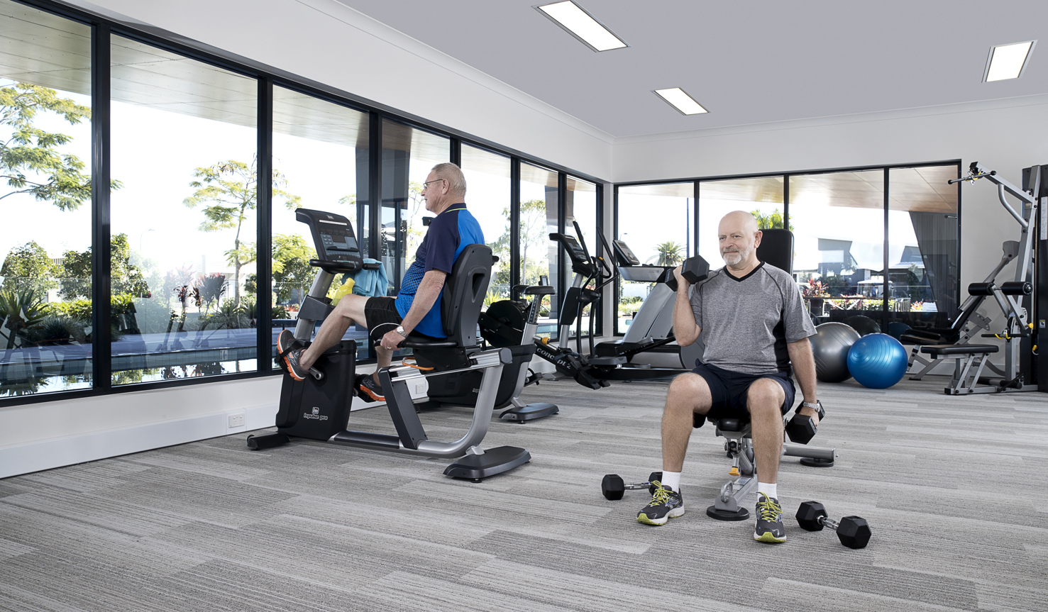 Active homeowners using gym and equipment at the Vision by Halcyon gym
