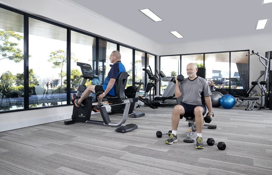 Active homeowners using gym and equipment at the Vision by Halcyon gym