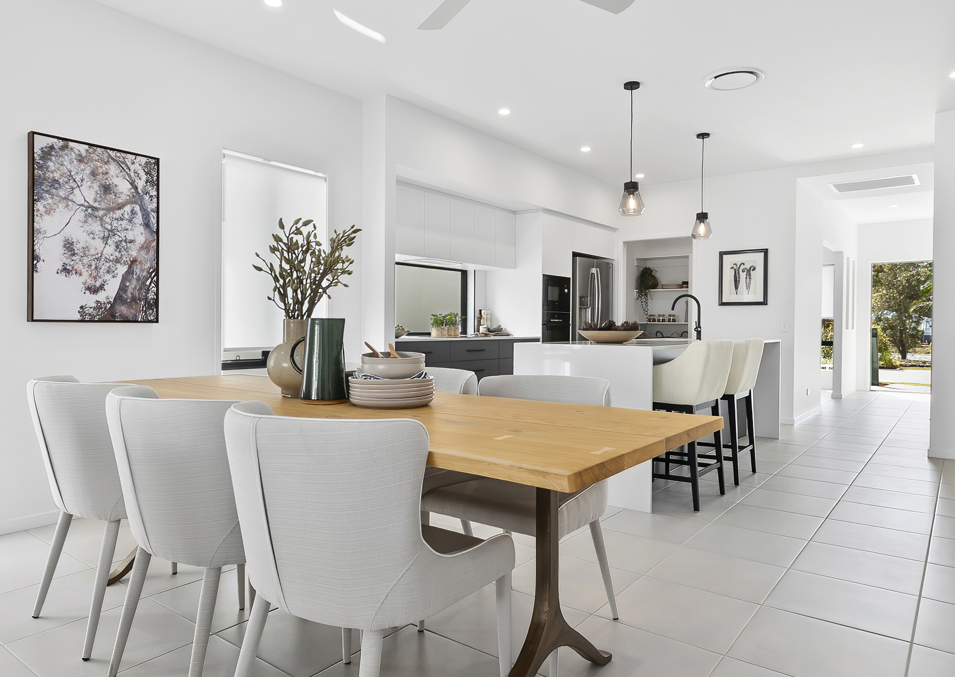 A modern kitchen and dining space within a display home at B by Halcyon in Buderim