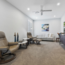 media room with modern furniture white walls and light brown carpet