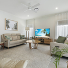 Living room interioir with leather recliner lounge chairs, beige styling and television.