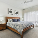 master bedroom with timber bedroom furniture suite and blue bedspread.