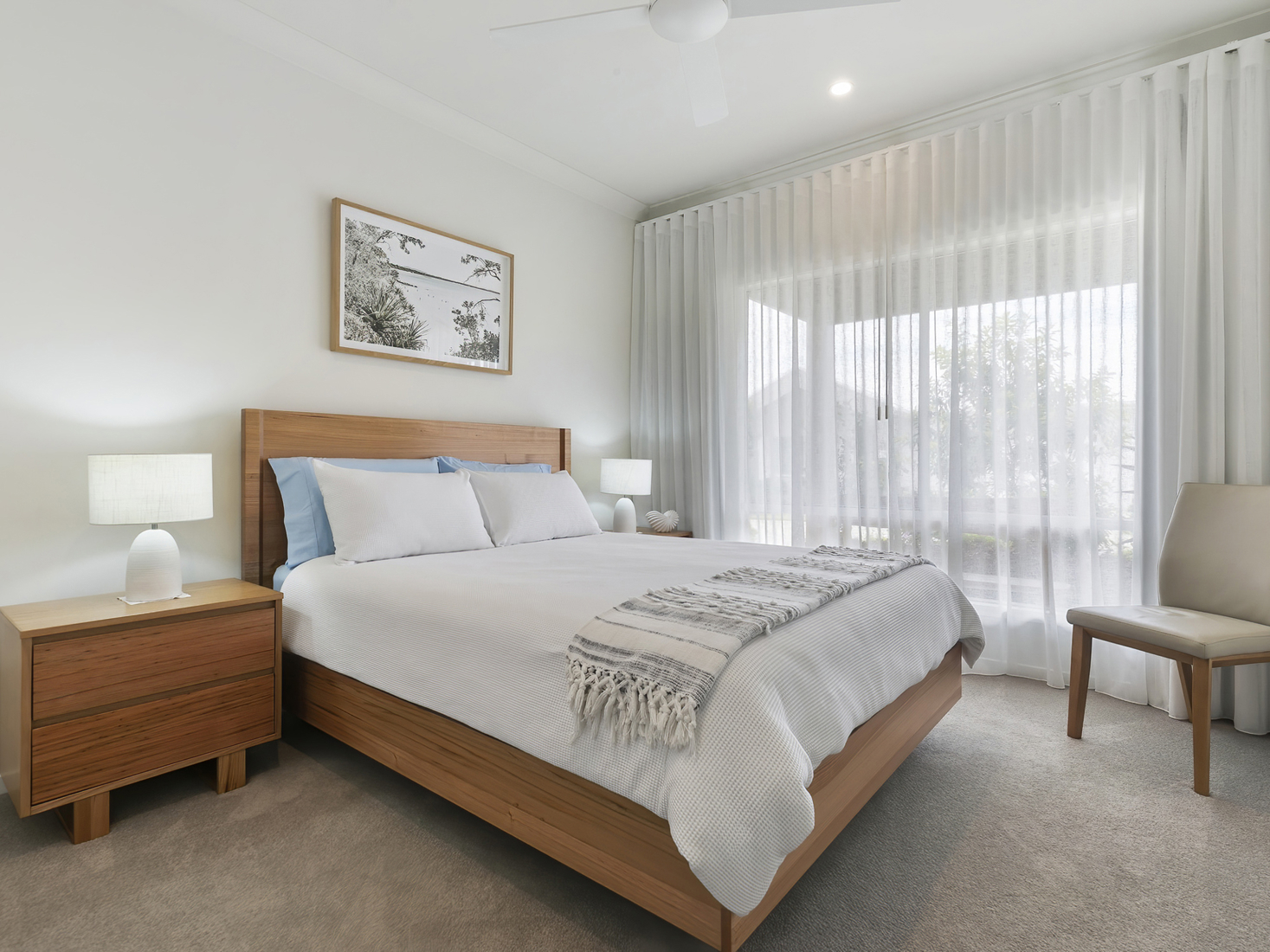 second master bedroom with timber bedroom furniture suite, beige walls and white bedspread.