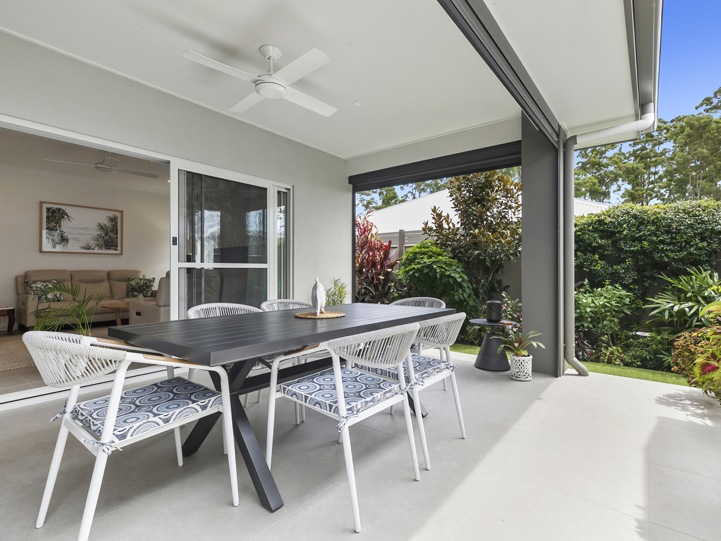 exterior rear patio with table and chairs at home in b by halcyon lifestyle community.