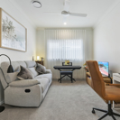 interior image of multi purpose room with white walls, neutral furniture and laptop. 