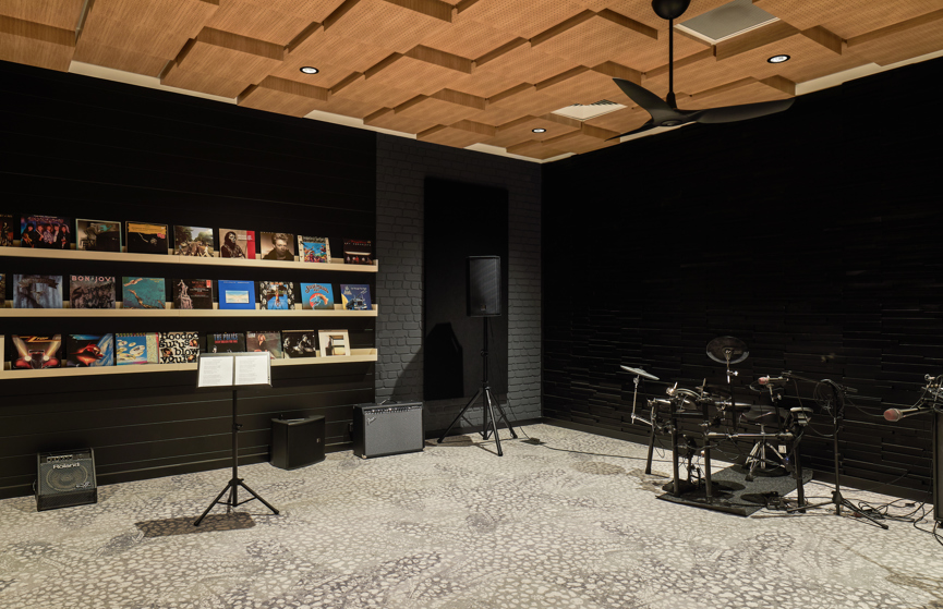 An interior image of a fully equipped music studio with records, music stand and drum kit at B by Halcyon.