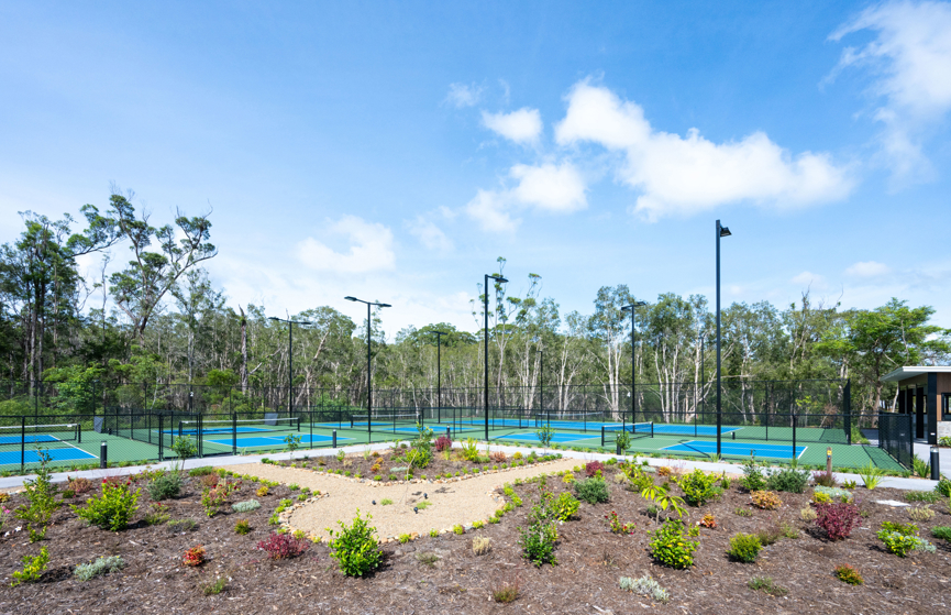 Pickleball and tennis courts surrounded by green bushland