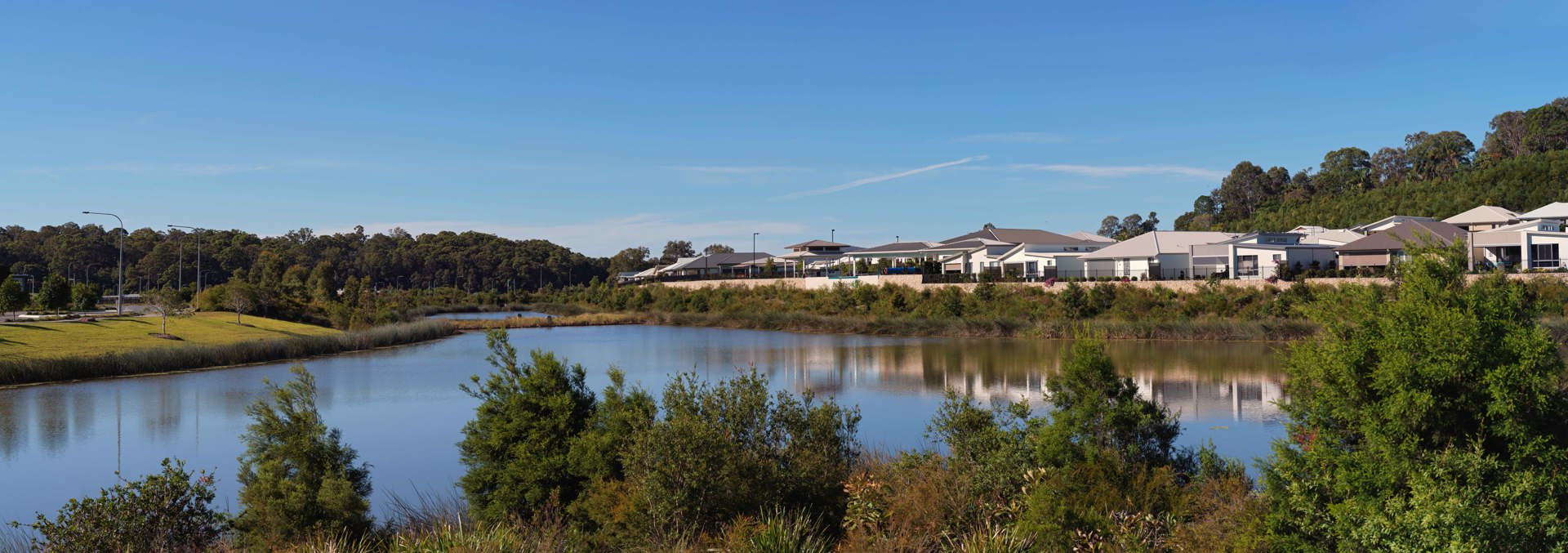 Landscape shot of Halcyon Lakeside lake with homes in the background