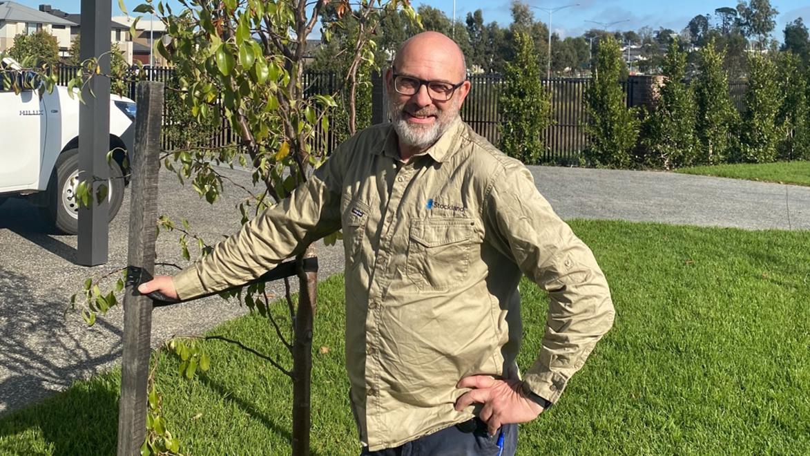 An image of Halcyon Jardin's caretaker Howard standing next to a growing tree at Halcyon Berwick.