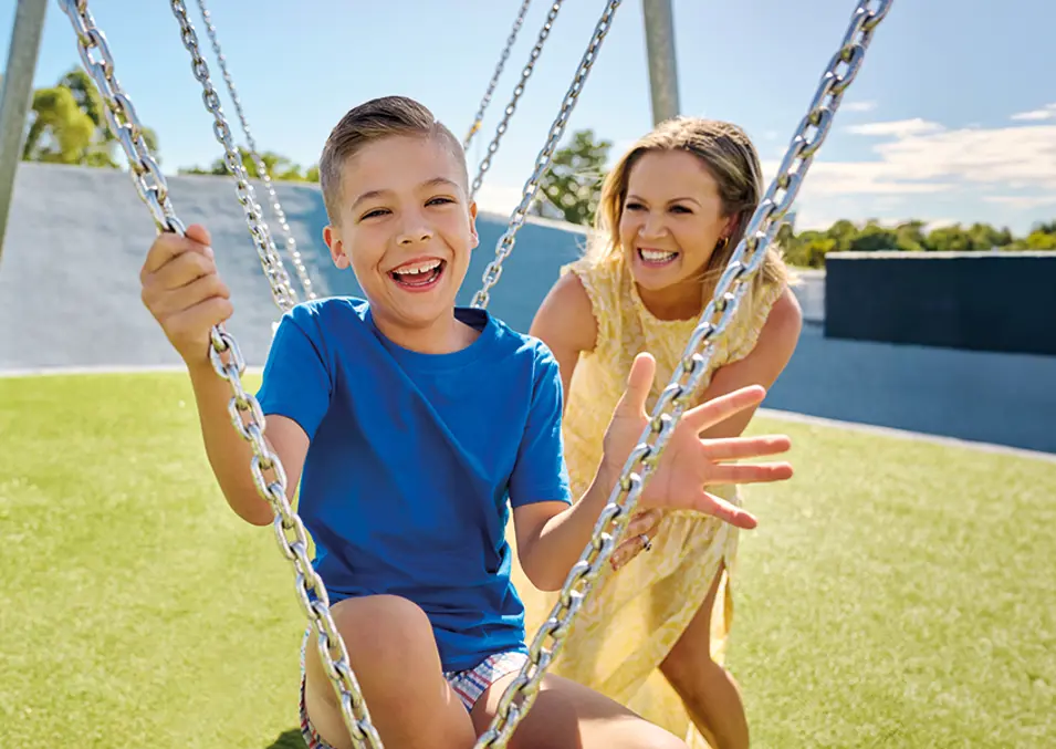 A mother pushing her kid's swing