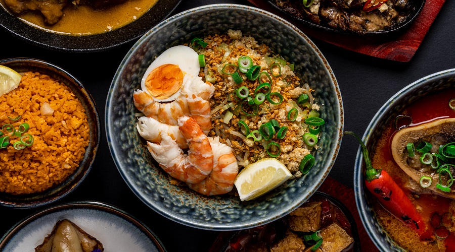 Pancit Malabon, a popular Filipino noodle dish featuring smoky pork and prawn sauce, topped with crunchy pork skin crackling