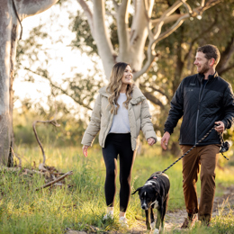 Couple walking dog amongst nature