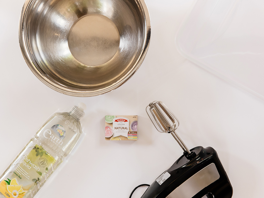 Assortment of kitchen items including mixing bowl, dish soap, food colouring and electric beater