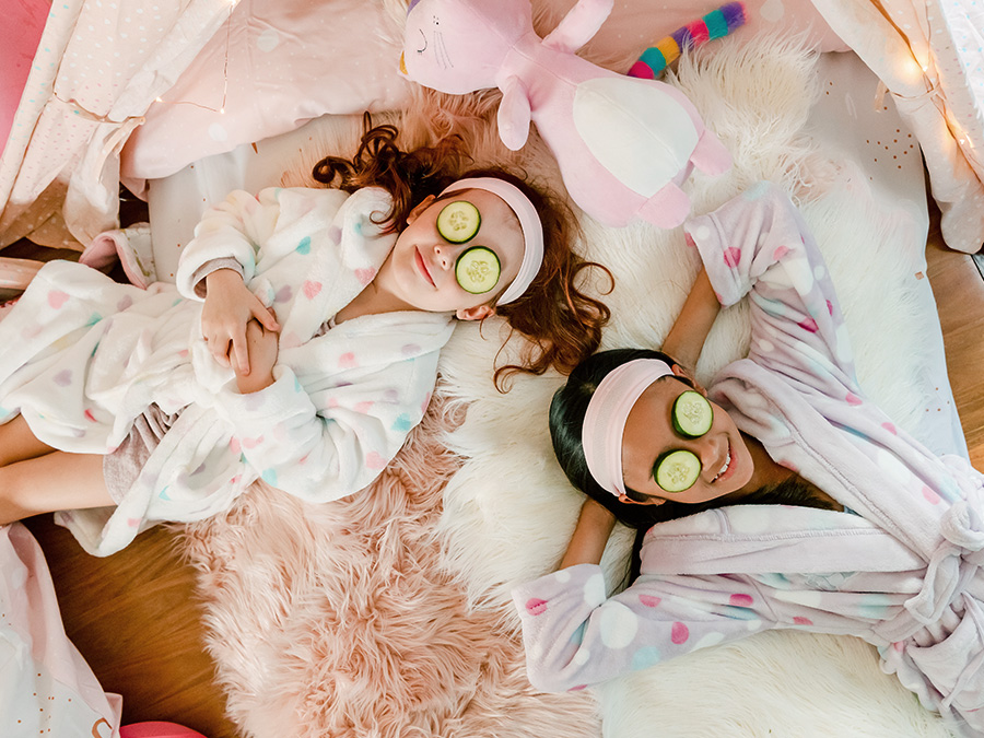 Girls lying down with cucumbers over there eyes