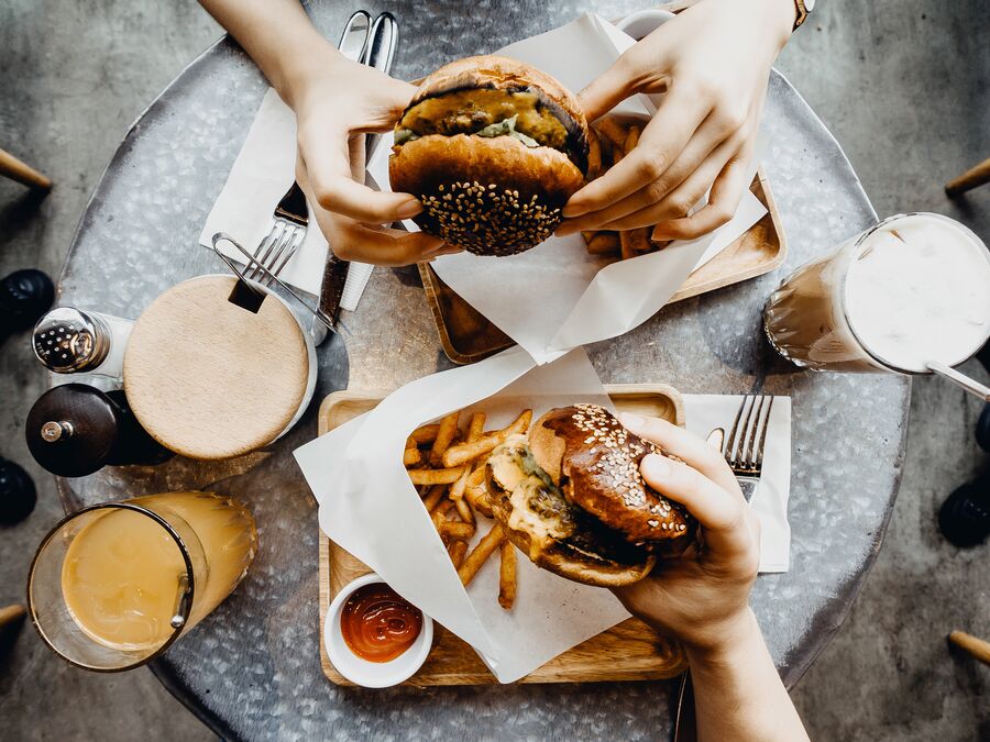 Above shot of people eating burger and chips