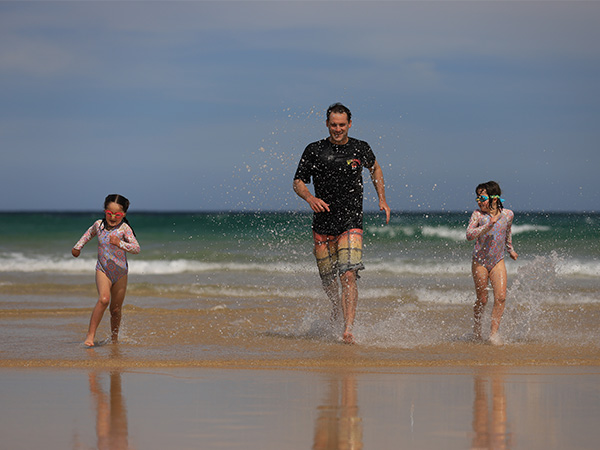 Father and daughters playing at the beach