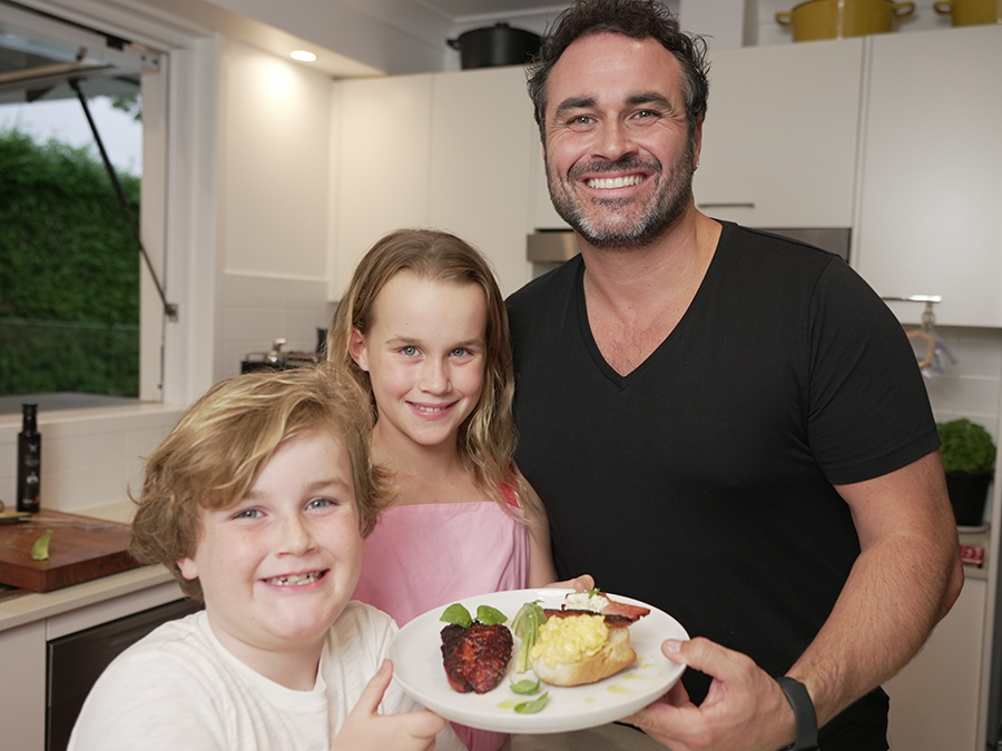 Miguel Maestre and his children holding a plate of scrambled eggs for Mother