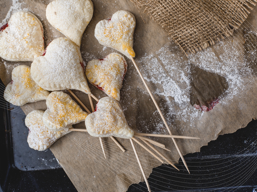Heart-shaped jam-filled biscuits on sticks