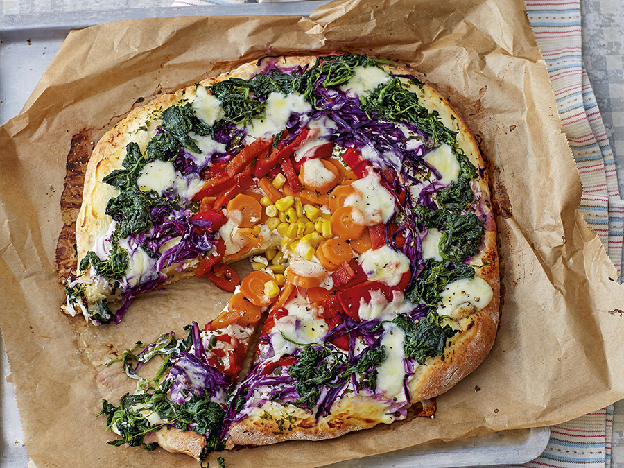 Vegetarian rainbow pizza served on baking paper