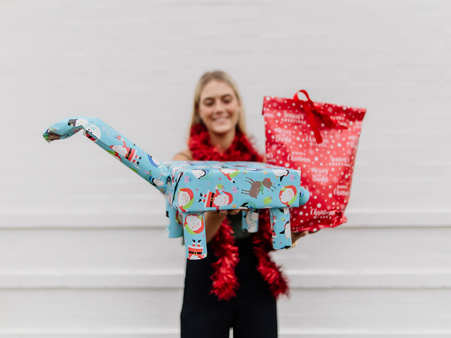 A woman holding wrapped Christmas gifts
