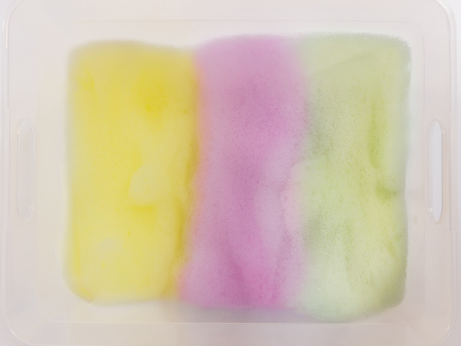 Yellow, purple, and green soap bubbles in a tub