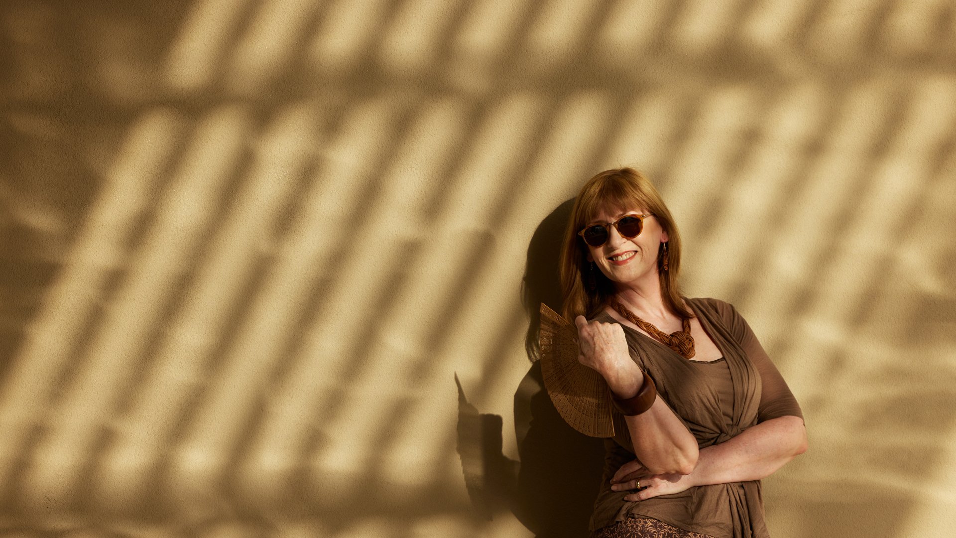 Lady holding fan looking relaxed and sophisticated