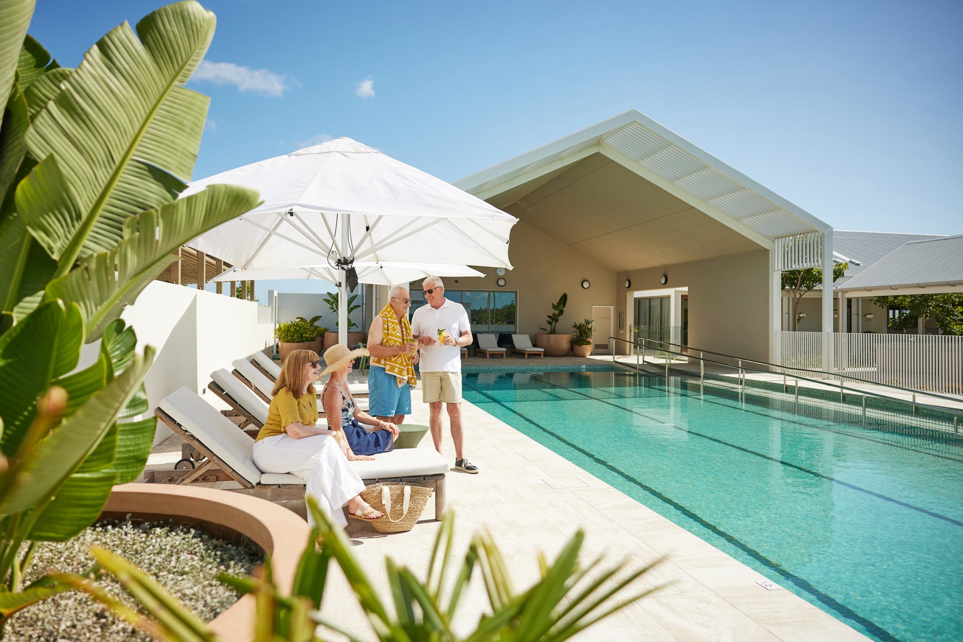Friends enjoying drinks and a relax by the Halcyon Nirimba pool side