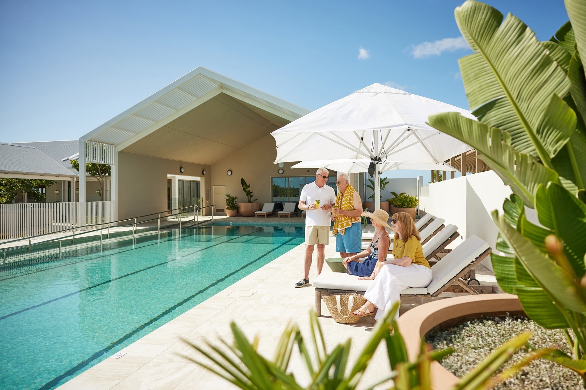 Friends enjoying drinks and a relax by the Halcyon Nirimba pool side