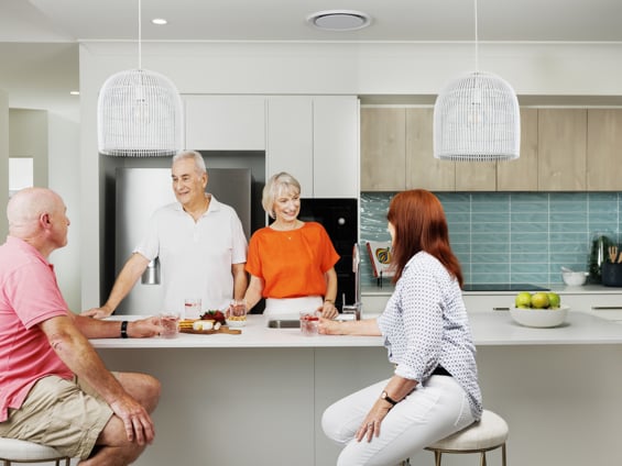 Couple enjoying morning tea with friends in the kitchen of their new Stockland Halcyon home