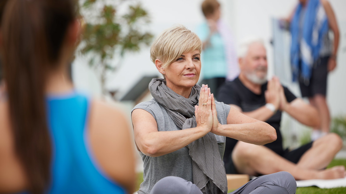 Friends enjoy a yoga class on the lawn, run by an instructor at a Stockland Halcyon community